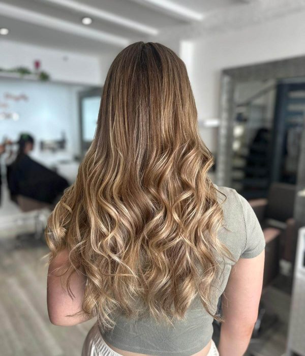 Rear view of young lady standing in the Woodbridge salon with long, freshly cut and styled hair